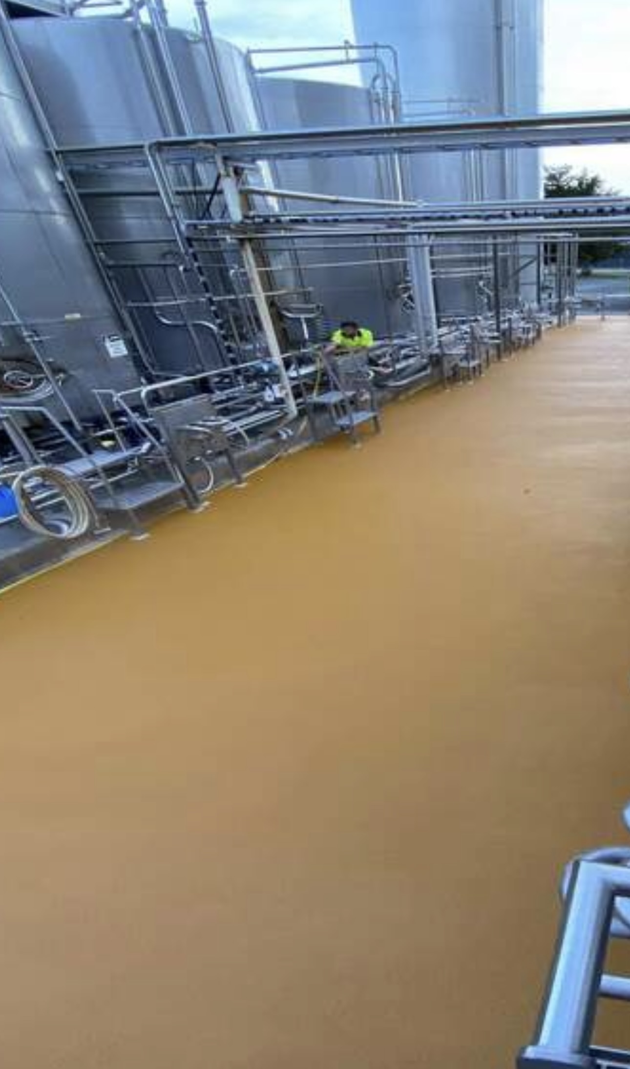 Epoxy-coated floor running between stainless steel silos at a dairy plant
